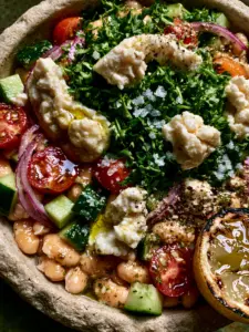 Close-up macro shot of a white bean salad showing glistening cannellini beans, diced cucumber, and flat-leaf parsley.