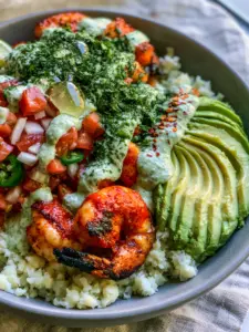 Close-up of succulent pan-seared shrimp with charred edges in a grey bowl for Shrimp and Avocado Bowls.