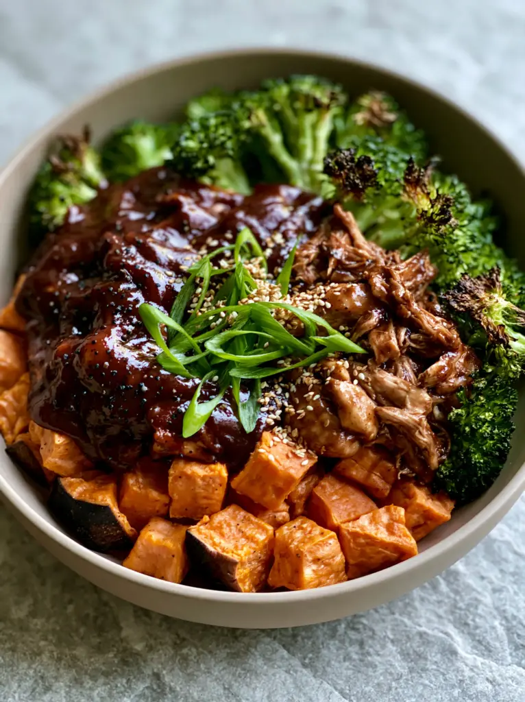 BBQ Chicken Sweet Potato Bowl: The Ultimate Caramelized Meal Prep Guide 2 Close-up of shredded chicken in glossy mahogany BBQ sauce with visible black pepper specks in a BBQ chicken sweet potato bowl.
