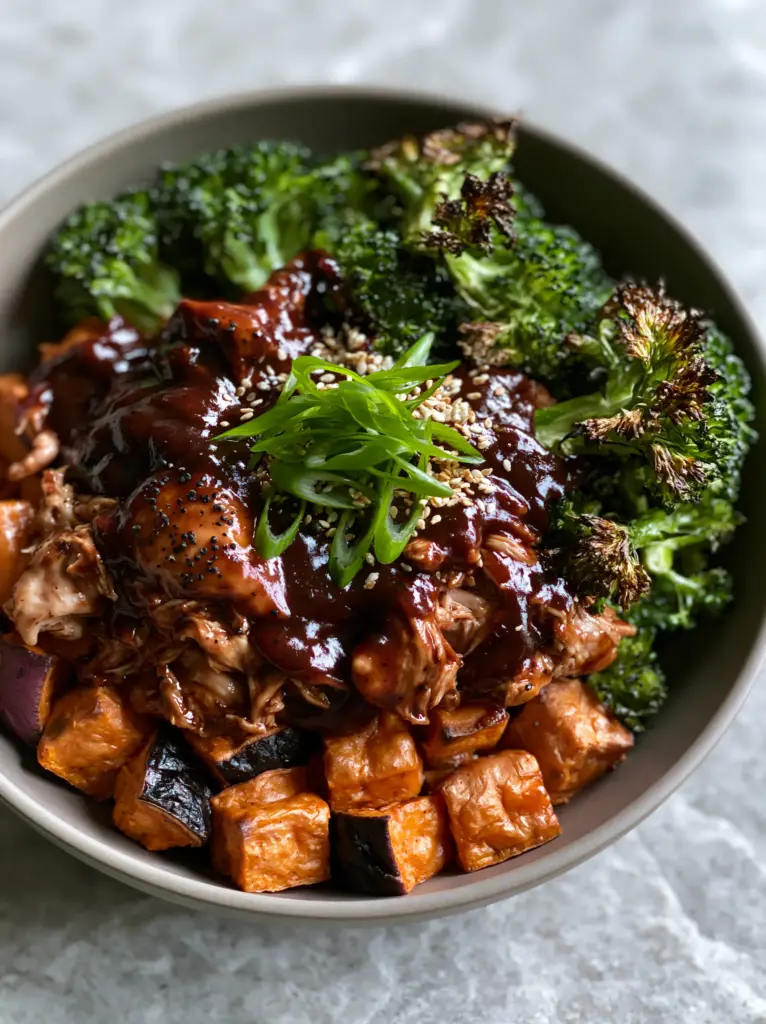 BBQ Chicken Sweet Potato Bowl: The Ultimate Caramelized Meal Prep Guide 1 Overhead shot showing the organized sections of a BBQ chicken sweet potato bowl on a stone surface.