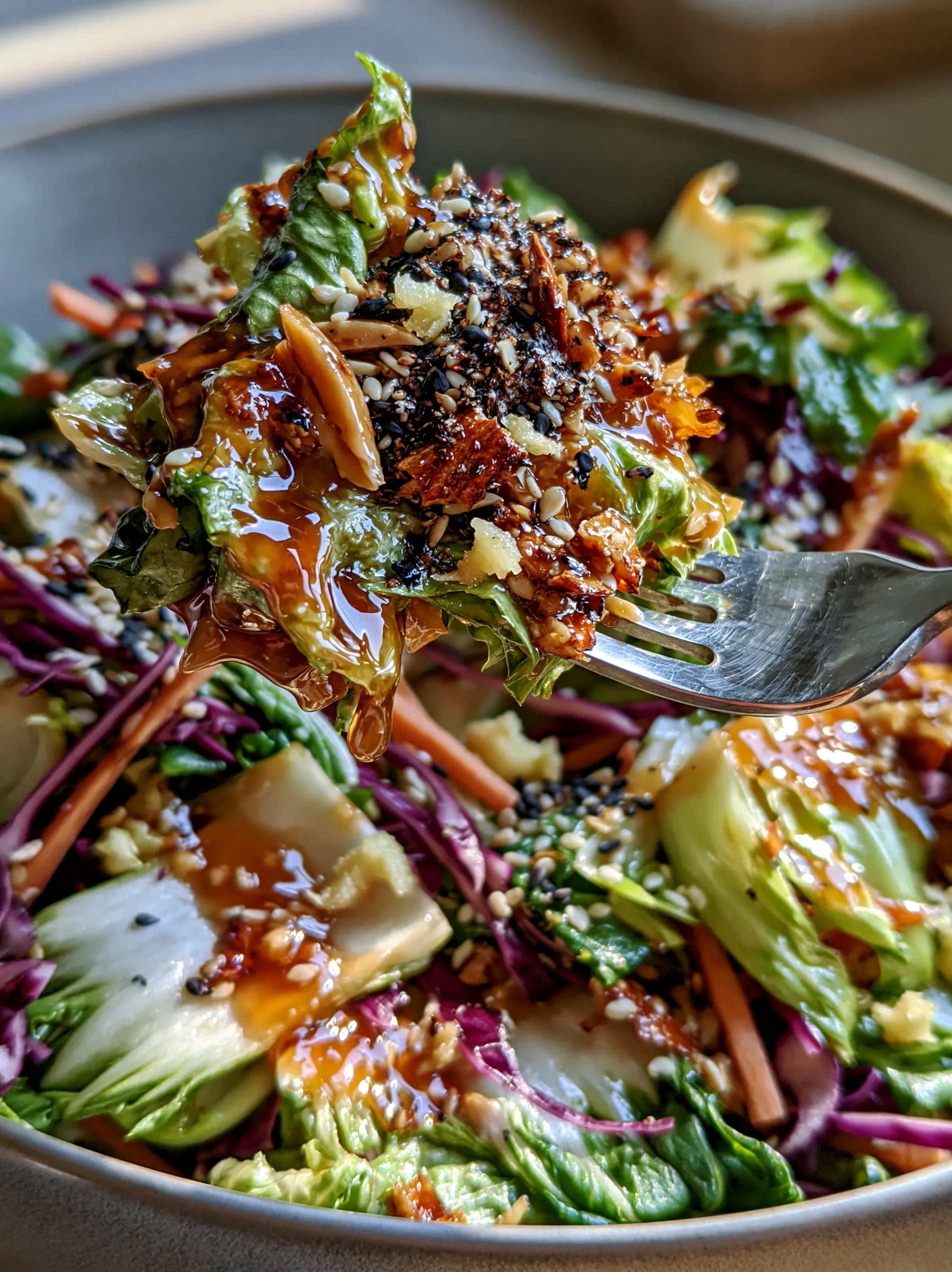 A top-down view of the bok choy salad showing the bright green leaves and matchstick carrots in a matte ceramic bowl. (bok choy salad)