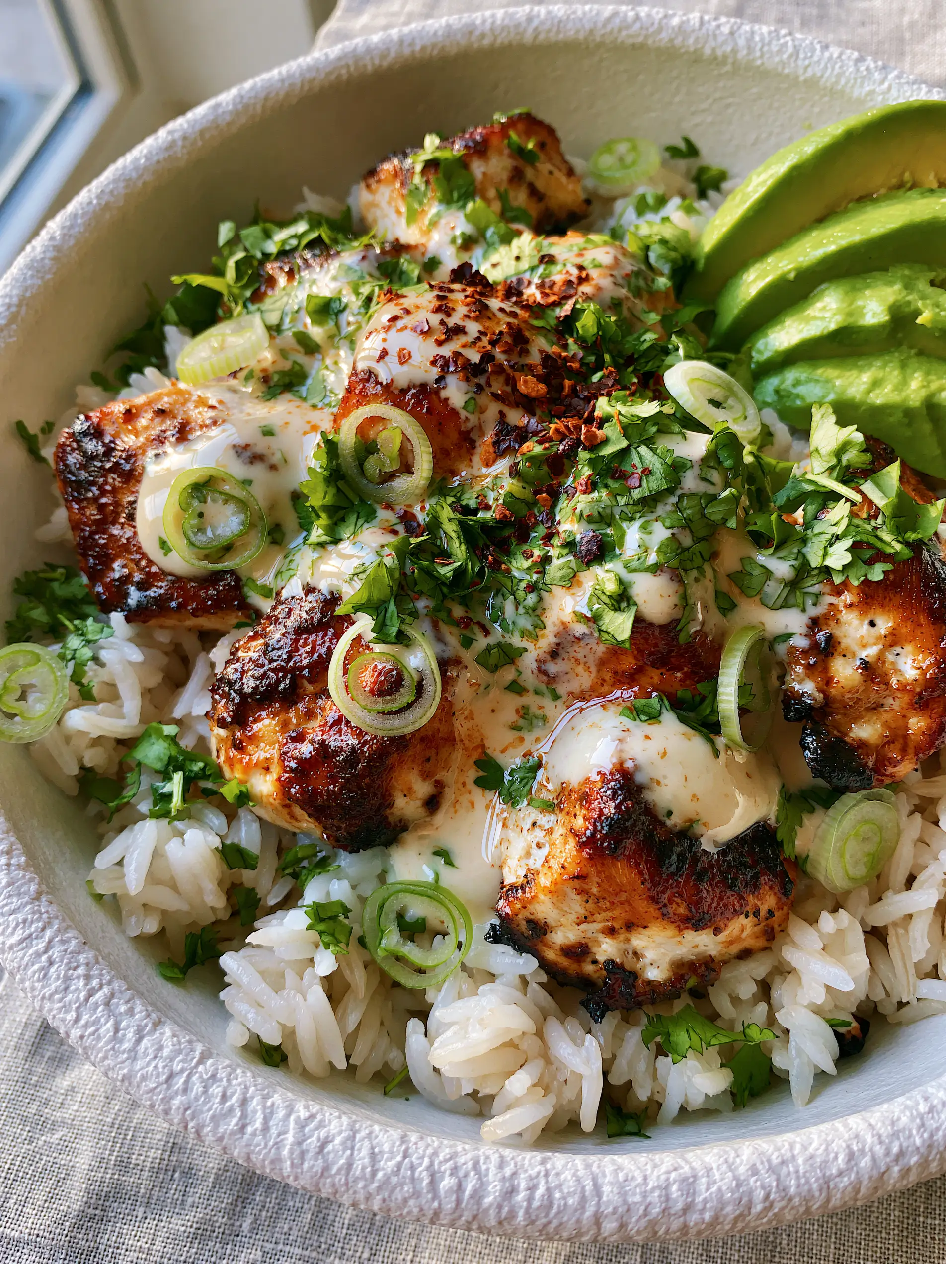 Coconut Chicken Rice Bowls with Creamy Ivory Sauce 3 Macro shot of Coconut Chicken Rice Bowls showing fluffy jasmine rice grains and chicken with golden-brown charred edges.