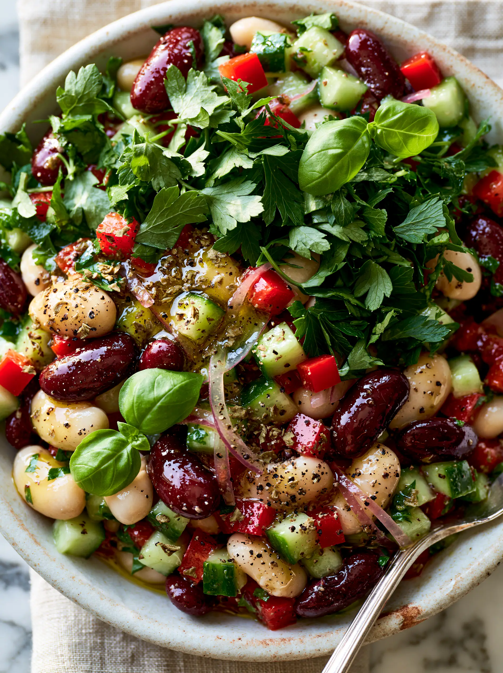 Italian Bean Salad with Shimmering Lemon-Herb Vinaigrette and Fresh Basil 4 Close-up of Italian bean salad showing creamy cannellini beans, dark red kidney beans, and crisp diced cucumbers coated in herb dressing.