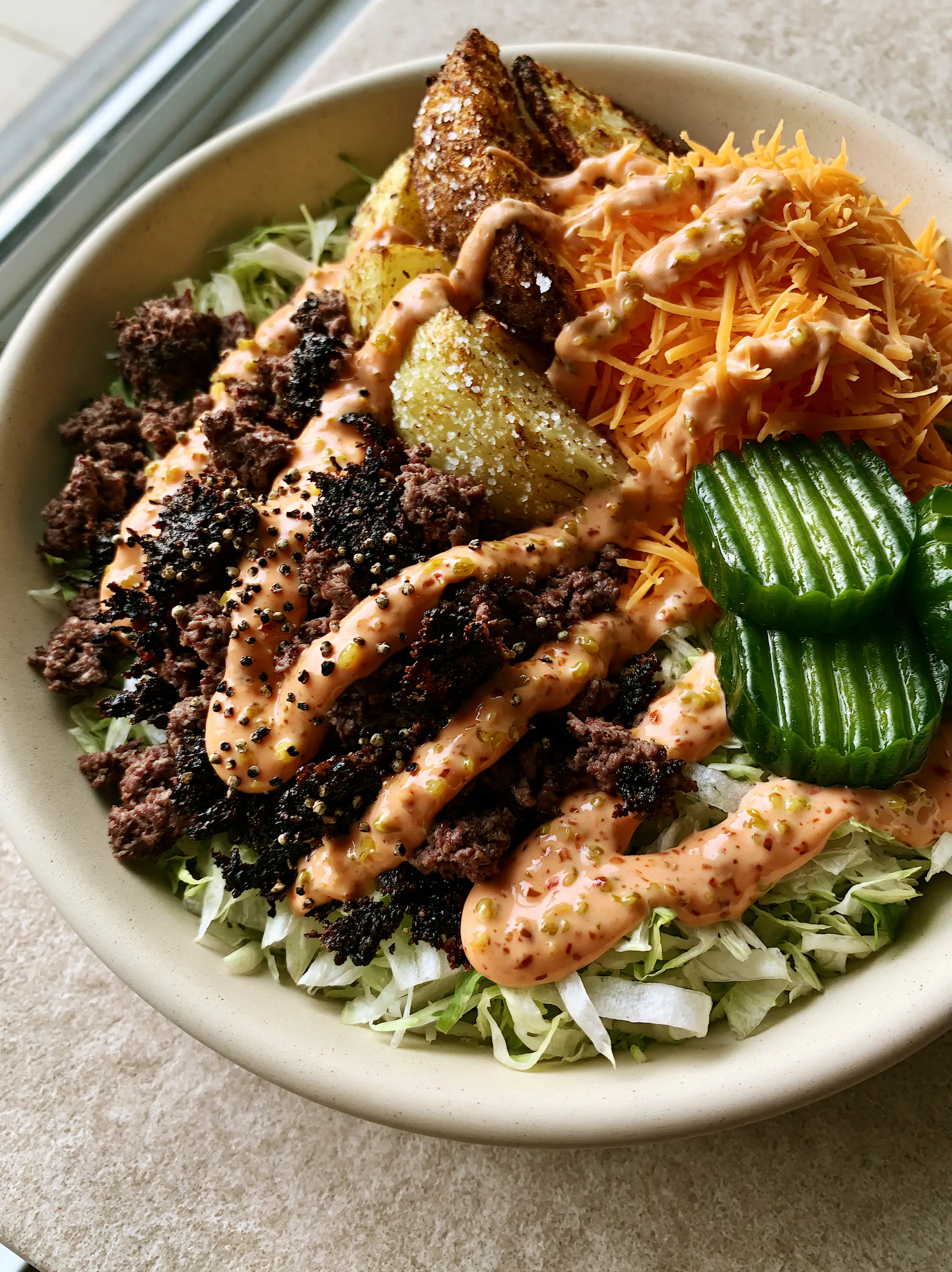 Close up of heavily seared ground beef with charred edges and cracked black pepper. (Burger Bowl Recipe)