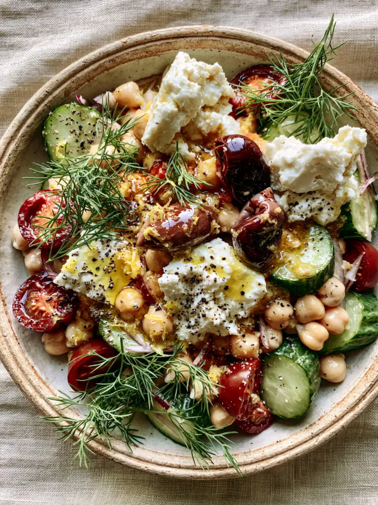 Greek Chickpea Salad with Herb-Infused Olive Oil and Rustic Feta 2 A high-detail close up of greek chickpea salad highlighting the thick-cut Persian cucumbers and golden herb-infused dressing.
