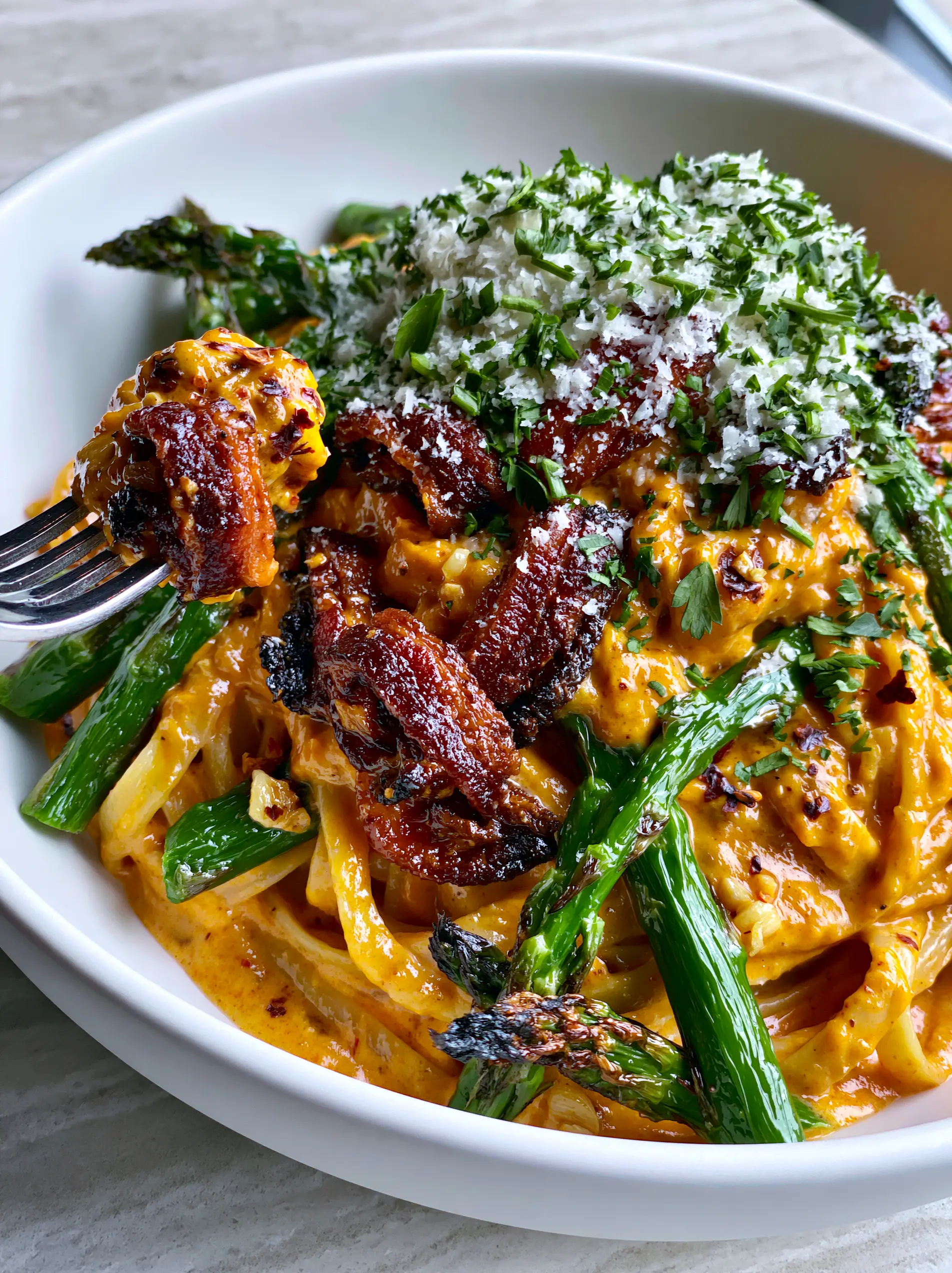 Bacon Asparagus Cajun Pasta with a Creamy Sunset-Orange Sauce 3 Close up shot of al dente linguine ribbons in a sunset-orange cream sauce with bacon lardons. (bacon asparagus cajun pasta)