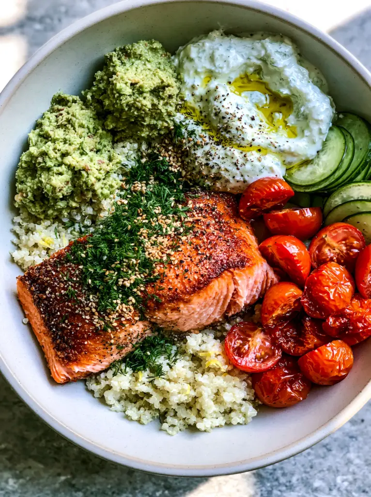 Light dinner ideas: Mediterranean Salmon Quinoa Power Bowl 2 Close-up of a pan-seared salmon fillet with crispy golden edges and moist pink flakes. (Light dinner ideas)
